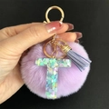 Gros plan sur le porte-clés à pompon violet avec lettre T en résine et sequins cœurs - Lettre T