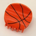 Detail shot of a round basketball-shaped claw clip with classic orange and black texture - Basketball