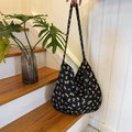 Chic black canvas tote bag featuring white bow patterns and wide shoulder strap - Twill Bowknot