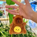 Brown plush capybara keychain with a yellow chick pattern and a golden metal clasp - Holding Chick Dark Brown + Gold Clip