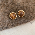 Primer plano de pendientes de ojo de tigre bañados en oro de 18k sobre telas naturales - Estilo Ojo de Gato Marrón Redondo con Marco Dorado Irregular (19#)