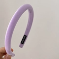 Close-up of lavender fabric headband showing the handmade label and soft texture - Purple