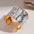 Primer plano de pulsera ancha vintage con patrón de serpiente gris e interior dorado - Estilo Serpiente Gris Y Blanco / Dorado