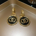 Vista macro de pendientes vintage de oro con colgante de esmalte negro y metal texturizado - Estilo de Aro Con Colgante Redondo / Dorado-Negro