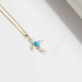 Goldene Kreuzkette mit weißen Perlen und ovalem Türkis-Stein am Anhänger für Damen - Perlenkreuz (Türkis)