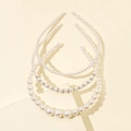 Detailed close-up of three pearl headbands with different bead sizes on stone props - Style B Mixed Size Pearl Headband 3-Piece Set