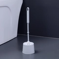 White plastic toilet brush set with long handle and base shown against grey wall - Nordic Grey