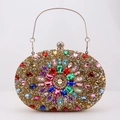 Close-up of gold rhinestone evening clutch with colorful gems and metal handle ring - Colorful Gold
