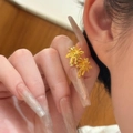 Close-up of gold palm tree stud earrings worn by a model with a minimalist background - Gold Stud Earrings (925 Silver Pin)
