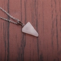 Detailed view of pink quartz triangular pendant on a silver chain over a wooden surface - Rose Quartz Triangle