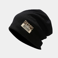 Detail of black ribbed knit beanie with leopard print patch and text design - Black