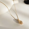 Close-up of golden woven water bottle pendant with bead chain on elegant background - Woven Design / Gold