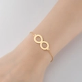 Minimalist gold infinity symbol bracelet with a sleek polished finish on a model wrist - 346-Infinity