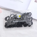 Detail view of black high-elastic hair ties in a daisy frosted zipper bag packaging - 50Pcs/Bag / Black Series