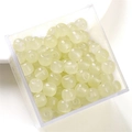 Pale yellow translucent glass beads stored in a transparent square plastic container - Light Yellow Apple Bead