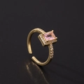 Détail de bague avec gemme rectangulaire rose, anneau doré ajustable et diamants incrustés - Style Halo Rectangulaire Classique