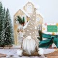 Close-up of Nordic Christmas gnome plush with white beard and brown knit hat - Brown