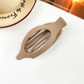 Detail view of a large brown matte hair claw clip on a white table with a coffee cup - Matte Light Coffee
