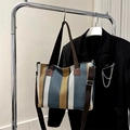 Multicolor striped canvas tote bag with adjustable brown shoulder strap on hanger - Blue
