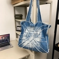 Blue denim tote bag with retro patchwork design and frayed edges on display - Light Blue
