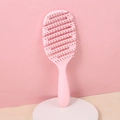 Spazzola scheletro rosa per volume e styling su un supporto cilindrico bianco - Rosa