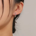 Silver geometric hoop earring with micro-paxed zircons worn by a model in close-up view - Zirconia Hoop Earrings - Silver (EP2538)