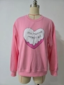 Détail d'un sweat oversize rose avec un cœur blanc et une impression de texte russe - S / Style de Stock Standard