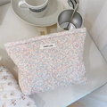 Neceser acolchado con estampado floral y etiqueta en una mesa de estilo acogedor - Flores Púrpura Rosado Claro