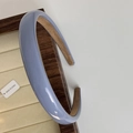 Detalle de diadema azul brillante con forro de ante marrón sobre un soporte de madera - Azul Niebla