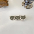 Close-up of triple cat-shaped hair clip in grey and cream white resin on white surface - Matcha Green