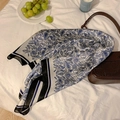 Eleganter Seidenschal mit blau-weißem Paisleymuster und stilvollen Accessoires drapiert - Blaues Paisley