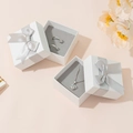 White jewelry gift box with silver ribbon bow for necklaces and rings in a lifestyle setting - White Box (Grey Sponge Inner)