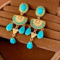 Dettaglio macro di orecchini vintage con pietre turchesi e perle bianche su velluto - Oro e Blu Turchese