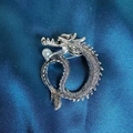 Detailansicht einer silbernen Drachenbrosche mit weißer Perle und Schuppenmuster - Silberner Drache Mit Perle