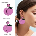 Pink peach acrylic earrings with green leaf detail and female model display - Peach