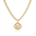 Dettaglio di un ciondolo a conchiglia dorato con perle bianche su una catena a maglie spesse - Collana conchiglia con perla dorata