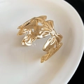 Makrodetail eines goldenen Metallarmreifs mit strukturiertem Schleifendesign - Bogen Stil (3#)