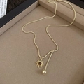Detailed macro of golden sun pendant with brown bead on sleek snake chain jewelry - Gold Sun Pendant Tiger Eye Necklace