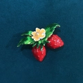 Lindo broche de fresa roja con hojas verdes y flor blanca sobre terciopelo - Flor de fresa doble