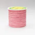 Close-up of 0.8mm pink braided cord for DIY jewelry on a white plastic spool - Color 1023 Pink