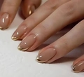 Macro view of oval nude pink press-on nails with shiny gold metallic French tips - Nude Pink Gold Metallic Tip (CW369)
