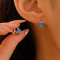 Primer plano de pendientes de huella en plata con circonitas azules en modelo - Estilo de garra de gato con piedra de corazón azul (A-1130) / Plateado