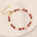 Detail of beaded bracelet with red stone, white pearls, and gold lobster clasp - Red Imperial Jasper