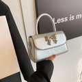 Silver metallic crossbody bag with a large bow clasp and cracked leather texture - Silver