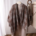 Detailed view of soft brown plaid scarf with fringe accents styled on a beige coat - Brown & Khaki Plaid