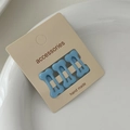 Close-up of three light blue bone-shaped hair clips on white ceramic plate - Light Blue (Set of 3)