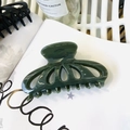 Dettaglio del fermaglio per capelli a fiore traforato verde scuro su sfondo bianco - Verde Scuro