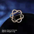 Macro detail of gold twin snake brooch with black crystals, measuring 3.1x3.1cm and 5.5g - Intertwined Double Snake (XZ24214)