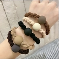 Set of 5 matte bead woven hair ties in brown, beige, and black on a model wrist - Frosted Ball Classic Hair Tie