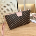 Brown and pink leather crossbody bag with gold clover floral pattern on wood surface - Pink